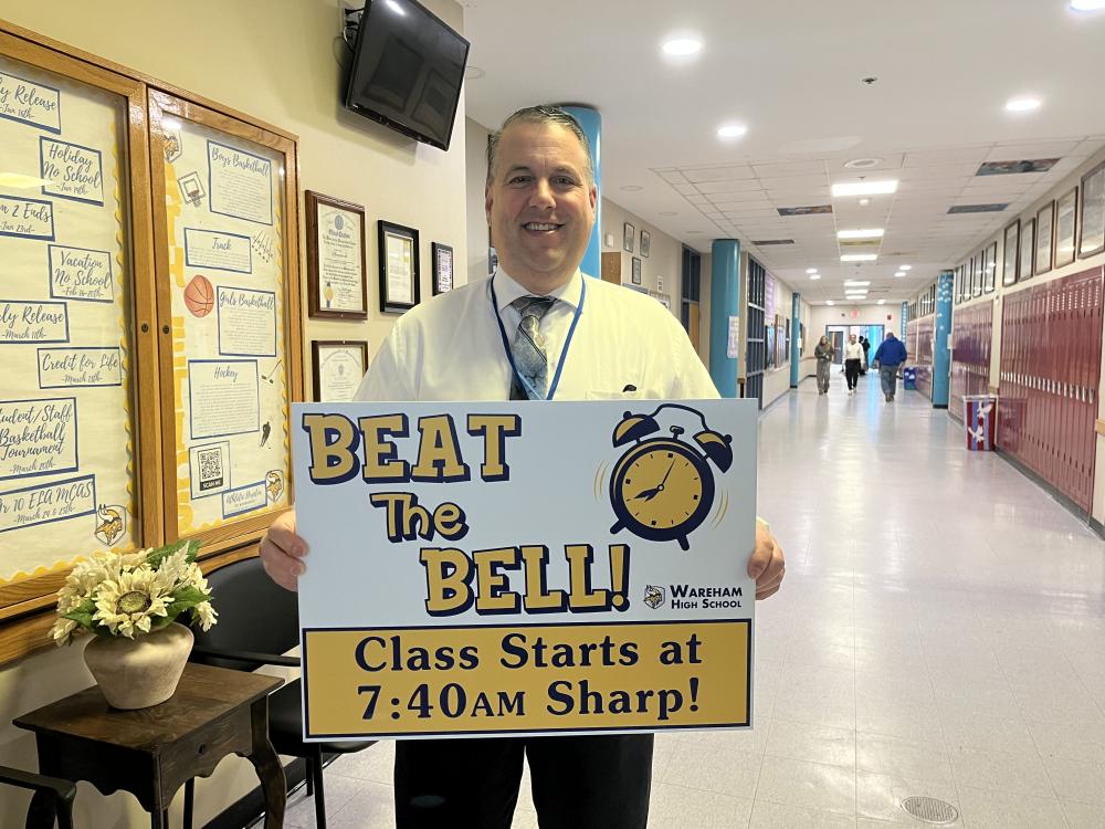 Wareham High School Principal Scott Palladino holds a sign reminding students to get to class before the morning bell. Photo by Grace Roche