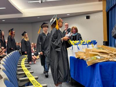 A student collects their diploma at the June graduation ceremony.