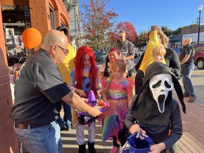 Costumed children take candy from a sombrero-shaped dish outside El Mariachi. 