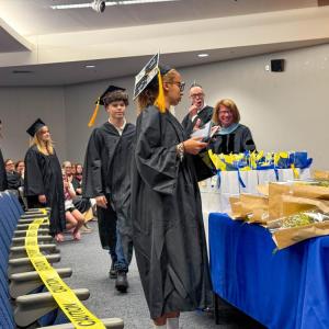 A student collects their diploma at the June graduation ceremony.