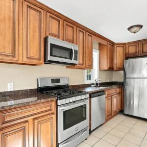 Wood kitchen cabinets with stainless refrigerator, microwave and range at 17 Beeden Road, Westport, MA