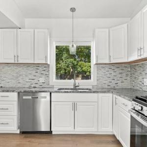 Renovated kitchen with white cabinets, granite counters, a tile backsplash and a gas range at 226 Sanford Road, Westport