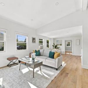 Living room with a vaulted ceiling, large windows and light wood floors at 226 Sanford Road in Westport, MA